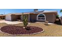 Charming brick home featuring a two-car garage, solar panels, arched windows and desert landscaping at 4054 E Clovis Cir, Mesa, AZ 85206