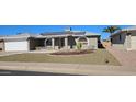 Charming brick home featuring a two-car garage, solar panels, arched windows and desert landscaping at 4054 E Clovis Cir, Mesa, AZ 85206
