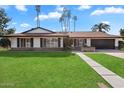 Ranch style home with lush green lawn and a long walkway leading to the entrance at 4421 W Laurie Ln, Glendale, AZ 85302