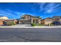 Two-story house with a three-car garage and manicured lawn at 46107 W Morning View Ln, Maricopa, AZ 85139