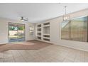 Bright living room with tile floors, a sliding glass door, and built-in shelving at 6497 S Twilight Ct, Gilbert, AZ 85298