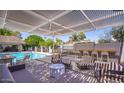 Relaxing poolside space with lounge chairs and a pergola at 7028 N Barbados Pl, Phoenix, AZ 85021