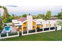 Stunning modern home with a private pool, patio, and fenced yard on a lush green lot at 8255 E Morgan Trl, Scottsdale, AZ 85258