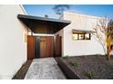 Contemporary home with modern landscaping and a custom wood slat gate at 8255 E Morgan Trl, Scottsdale, AZ 85258