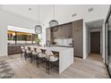 Kitchen island with counter seating, stylish pendants, and high-end cabinetry at 8255 E Morgan Trl, Scottsdale, AZ 85258