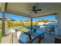 Covered patio with seating area overlooking the pool and grassy yard at 8732 E Valley Vista Dr, Scottsdale, AZ 85250