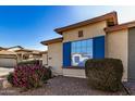 Close-up view of a house exterior with blue shutters and landscaping at 8805 W Windrose Dr, Peoria, AZ 85381