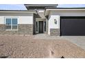 Front entrance with stone veneer and a metal door at 10229 N 177Th Dr, Waddell, AZ 85355