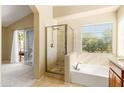 Main bathroom featuring tile floors, a glass shower, and a soaking tub with a window view at 11825 S 46Th St, Phoenix, AZ 85044