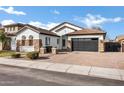 Beautiful house with white stucco, stone accents, tile roof, brick driveway, and a two-car garage at 1612 E Zion Way, Chandler, AZ 85249