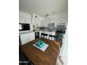 Eat-in kitchen with white cabinets, mosaic backsplash and wood flooring at 524 W Fairway Dr # 12, Mesa, AZ 85201