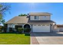 Two-story house with a gray exterior, two-car garage, and landscaped lawn at 6113 W Desert Hills Dr, Glendale, AZ 85304