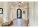 Grand entryway with high ceilings, elegant chandelier, and ornate columns at 13462 E Wethersfield Rd, Scottsdale, AZ 85259