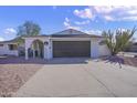 White single story home with a dark brown garage door and a neatly landscaped yard at 1703 E Laguna Dr, Tempe, AZ 85282