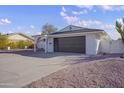 Charming single story home with a dark brown garage door and a white exterior at 1703 E Laguna Dr, Tempe, AZ 85282