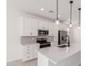 Updated kitchen with stainless steel appliances, white cabinetry, and modern lighting at 18556 E Dario Rd, Gold Canyon, AZ 85118