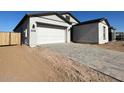 New construction home with gray exterior, two-car garage, and wooden fence at 22717 E Saddle Way, Queen Creek, AZ 85142