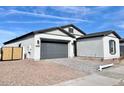 View of the home's front exterior featuring a brick driveway, two-car garage, and desert landscaping at 22740 E Lords Way, Queen Creek, AZ 85142