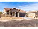 One-story house with brown roof and gray exterior, two-car garage, and desert landscaping at 2355 N Oakmont Ln, Casa Grande, AZ 85122