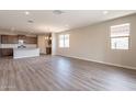 Bright and airy living space with large windows and recessed lighting, showcasing the hardwood flooring at 24153 W Hilton Ave, Buckeye, AZ 85326