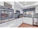 Modern white kitchen with stainless steel appliances and granite counters at 25227 S Mohawk Dr, Sun Lakes, AZ 85248