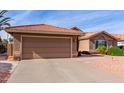 Tan house with tile roof, garage, and landscaped yard at 25432 S Queen Palm Dr, Sun Lakes, AZ 85248