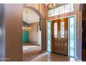 Elegant foyer featuring tile flooring, a decorative front door, and views into the dining room at 25440 S Flame Tree Dr, Sun Lakes, AZ 85248