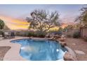 Inviting kidney-shaped pool with a waterfall feature and patio furniture at 25802 N Hackberry Dr, Phoenix, AZ 85083