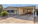 View of the front of the manufactured home, showcasing carport and landscaping at 2724 N Wright Way, Mesa, AZ 85215