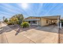 Well-maintained manufactured home with carport and mature desert landscaping at 2724 N Wright Way, Mesa, AZ 85215