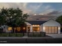 Modern farmhouse exterior with a white facade, dark wood accents, and a landscaped front yard at 3837 E Heatherbrae Dr, Phoenix, AZ 85018