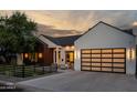 Modern farmhouse exterior with a white facade, dark wood accents, and a landscaped front yard at 3837 E Heatherbrae Dr, Phoenix, AZ 85018