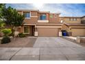 Two-story house with tan exterior, two-car garage, and landscaping at 4723 W Gelding Dr, Glendale, AZ 85306