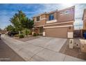 Two-story house with tan exterior, two-car garage, and landscaping at 4723 W Gelding Dr, Glendale, AZ 85306