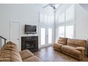 Bright living room with a fireplace, two sofas, and double doors leading to a patio at 602 N May St # 47, Mesa, AZ 85201