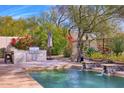 Outdoor kitchen with built-in grill and stone countertops at 7257 E Visao Dr, Scottsdale, AZ 85266