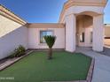 Landscaped front yard with artificial turf and a decorative plant at 9561 W Debbie Pl, Arizona City, AZ 85123