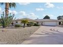 Single story home with a large driveway and desert landscaping at 9729 W Pinecrest Dr, Sun City, AZ 85351