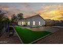 Backyard oasis with a lush faux grass patch, patio area, and privacy fencing perfect for outdoor enjoyment at 13022 W Surrey Ave, El Mirage, AZ 85335