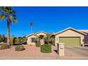 Front view of a tan house with a green garage door and palm trees at 14790 W Merrell St, Goodyear, AZ 85395