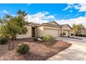 Tan two-story house with two car garage and desert landscaping at 42493 W Candyland Pl, Maricopa, AZ 85138