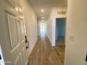 Bright hallway showcasing wood-look tile flooring, recessed lighting, and neutral paint scheme at 46941 W Old Timer Rd, Maricopa, AZ 85139