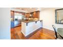Contemporary kitchen features stainless steel appliances, dark wood cabinetry, granite counters, and hardwood flooring at 4909 N Woodmere Fairway -- # 2003, Scottsdale, AZ 85251