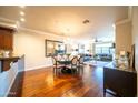 Bright, open-plan living area with dark wood floors, modern furnishings, and an elegant dining set perfect for entertaining at 4909 N Woodmere Fairway -- # 2003, Scottsdale, AZ 85251