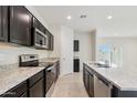 Modern kitchen features dark cabinetry, granite countertops, and stainless steel appliances at 641 W Freedom St, Florence, AZ 85132