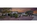 Desert landscaping surrounds this house with trees, plants, and red rock at 12953 W Figueroa Dr, Sun City West, AZ 85375
