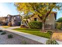 Two-story house with stone accents and a tree in front at 15244 W Alexandria Way, Surprise, AZ 85379