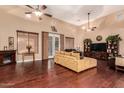 Spacious living room with hardwood floors, a large sectional sofa, and a fireplace at 15244 W Alexandria Way, Surprise, AZ 85379
