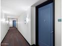 Hallway view with a blue door and black trim, leading to additional units with visible exit signs at 310 S 4Th St # 908, Phoenix, AZ 85004