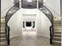 Grand curved staircase with wrought iron railing at 3957 E Expedition Way, Phoenix, AZ 85050